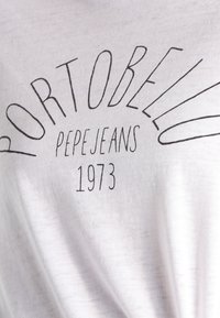 White cotton T-shirt featuring black screen-printed text reading "PORTOBELLO PEPEJEANS 1973" in a curved design. Soft texture, simple design.