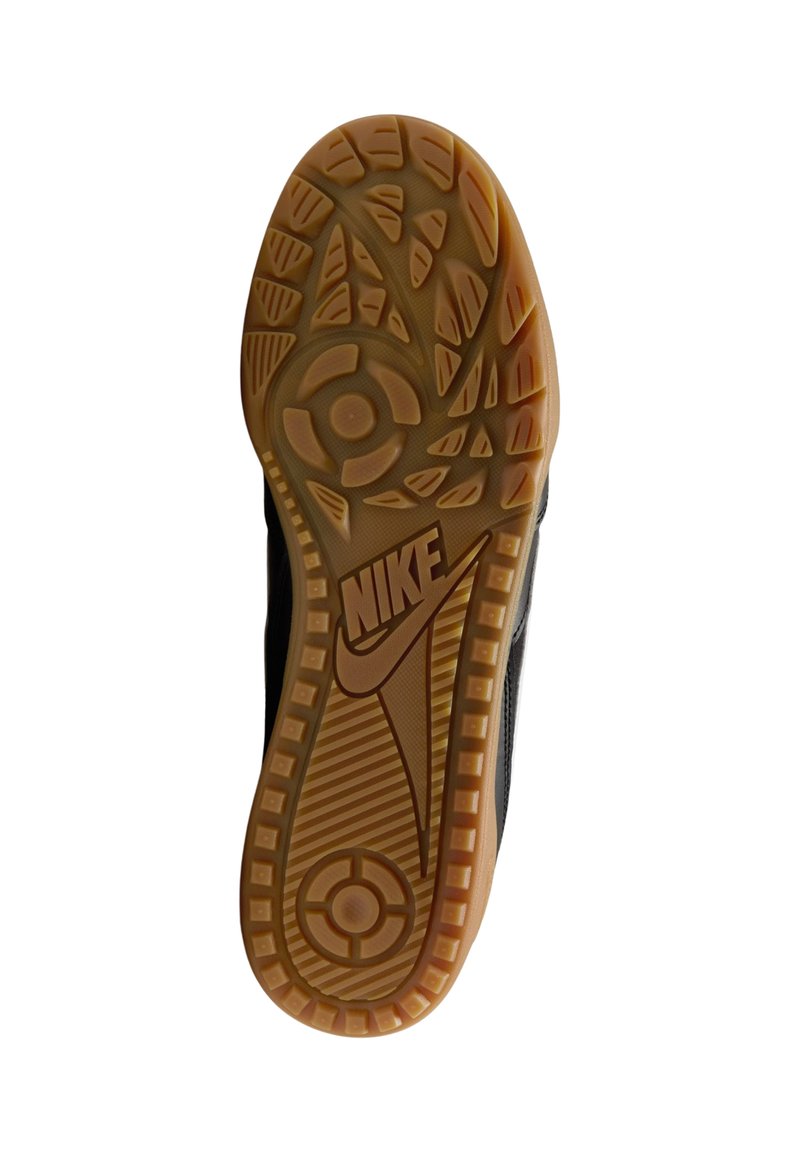 Suola di sneaker Nike in gomma naturale, con un motivo testurizzato, accenti circolari e un logo Nike ben visibile sul lato.