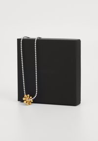 Strieborný guľový reťazec s pozláteným príveskom vo forme kvetu, vystavený na čiernej darčekovej krabičke. Hladký povrch a leštený finiš.