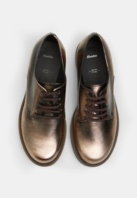 Scarpe in pelle bronzo con una texture liscia, punta rotonda e lacci marrone scuro. Presentano il marchio "Bata" e una soletta imbottita.
