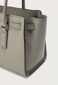 Τσάντα χειρός από δέρμα με γκρι υφή, δομημένο σχήμα, κοντές λαβές και ραφές σε αντίθεση. Διαθέτει μεταλλικές λεπτομέρειες και ανοιχτό επάνω μέρος.