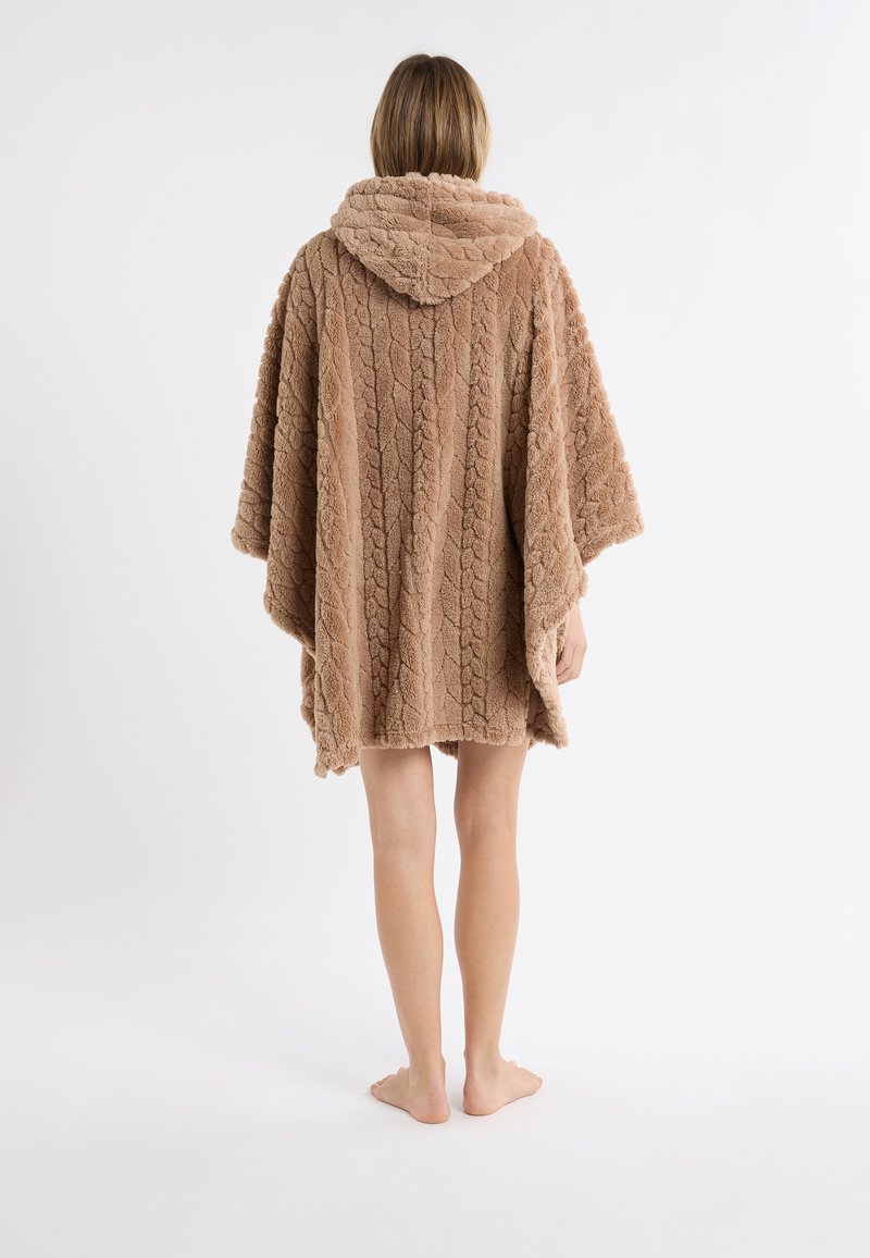 Brązowy, teksturowany, oversize’owy poncho z kapturem. Posiada wzór w warkocze. Wykonany z miękkiego, pluszowego materiału. Kończy się nad kolanami.