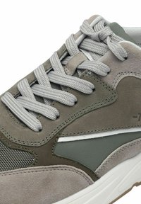 Idrottsskor i en blandning av gråmocka och nätmaterial, rundad tå, grå snören och en vit mellansula med subtila sy detaljer.