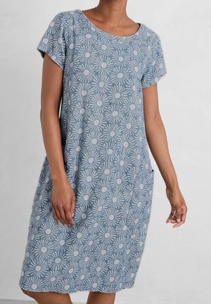 Niebieska sukienka z krótkim rękawem o delikatnym, kwiatowym wzorze przypominającym rozbłysk słoneczny, długość do kolan, z przednimi kieszeniami, noszona przez osobę o średnim odcieniu skóry.