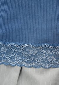 Kék bordázott anyag csipkés szegéllyel, világosszürke csíkos anyagon.