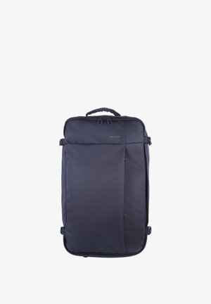 Valigia rettangolare blu scuro in materiale morbido con manico superiore, tasca frontale con cerniera, cinturini di compressione laterali e logo "TUCANO" sul pannello frontale.