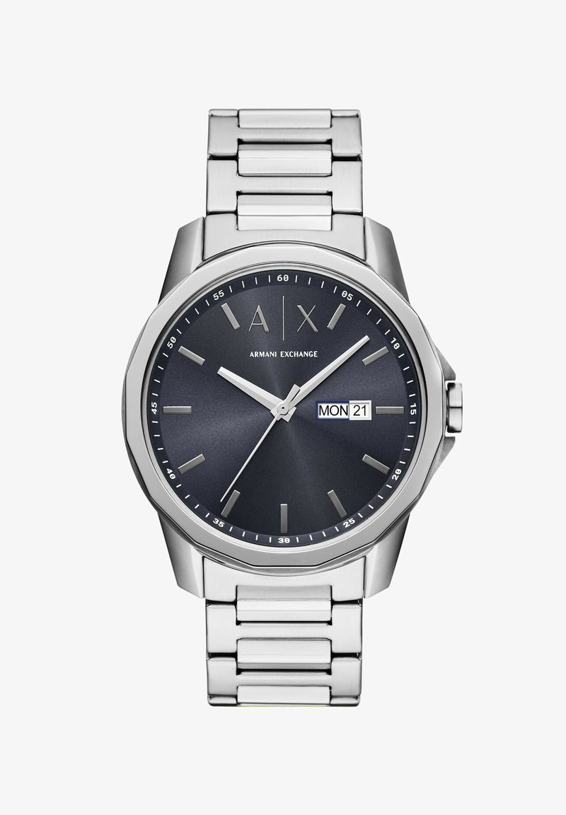 Klocka i rostfritt stål med en mörkblå urtavla, silverfärgade timmarkörer, datumvisning och ett borstat metallarmband. Rund kammardesign.