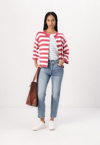 Rood-wit gestreepte cardigan, blauw gestreepte t-shirt, hoge taille jeans, witte schoenen, bruine tas, gepresenteerd op een neutrale achtergrond.