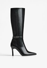 Cizme negre din piele până la genunchi, cu vârf ascuțit, toc subțire de tip stiletto și o curea decorativă cu cataramă argintie la gleznă.