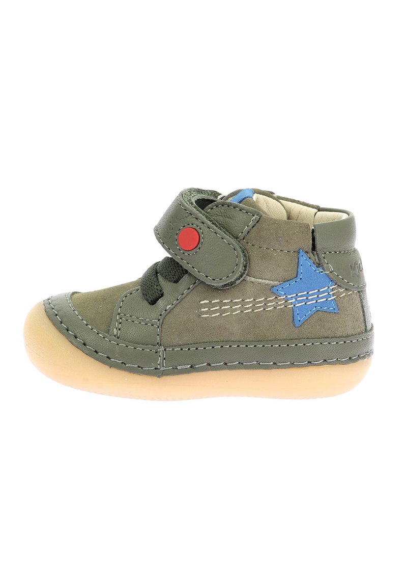 Zapato alto de cuero verde con acento de estrella azul, correa de Velcro roja, cordones negros y suela de goma beige; presenta detalles de costura.