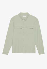 Camisa de botones de manga larga verde claro con dos bolsillos de solapa en el pecho y un cuello clásico, dispuesta sobre un fondo blanco.