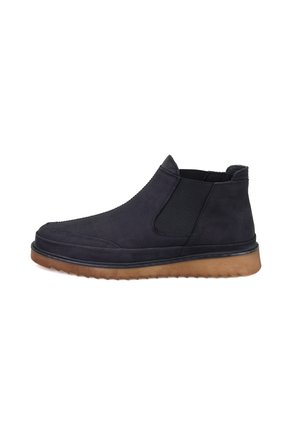 Schwarze Wildleder-Stiefeletten mit elastischen Seitenpaneelen und einer strukturierten braunen Gummisohle. Elegantes Design mit runder Zehenpartie und verstärkter Naht.