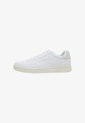 Witte lage sneaker met vetersluiting, subtiele stiksels en een iets gebroken witte zool, zijaanzicht naar links gericht.