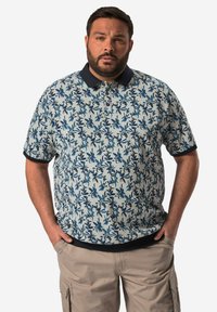 Kortärmad polo t-shirt i ljusblått med ett mörkblått blommönster, utrustad med mörkblå krage och ribbade ärmslut. Design med avslappnad passform.
