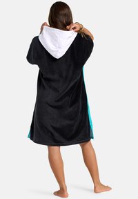Čierny plážový uterák s kapucňou a tyrkysovými bočnými panelmi, vyrobený z mäkkého materiálu. Znášajúci bielu kapucňu a voľný, nadmerný strih.