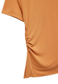 Kortærmet, orange top lavet af blødt stof har sammensamling detaljer på siden og en sideslids nær kanten.