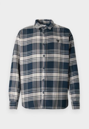 Kék és fehér kockás ing gombos gallérral, hosszú ujjal és egyetlen mellzsebbel. Texturált anyagból készült, látható varrással.