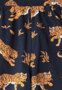 Navy Baumwollstoff mit einem orangenen Tigerdruck zwischen grünem Laub, mit einem elastischen Bund für eine bequeme Passform.