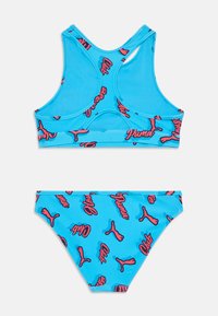 Modri bikini komplet, ki vsebuje športni top brez rokavov z obliko za dirkače in usklajene hlačke, oba okrašena s poudarkami v roza barvi z logotipom.