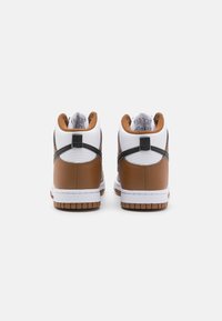 Valged nahast ülemise osa, pruuni nahkdetailide ja musta aktsendiga kõrged sneakersid. Omab tekstuuriga kummist tallat ja polsterdatud kaela.