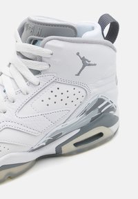 Hvite skinnsneakers med grå detaljer, perforerte partier, snøring og en synlig luftpute i sålen. Jumpman-logoen er påført.