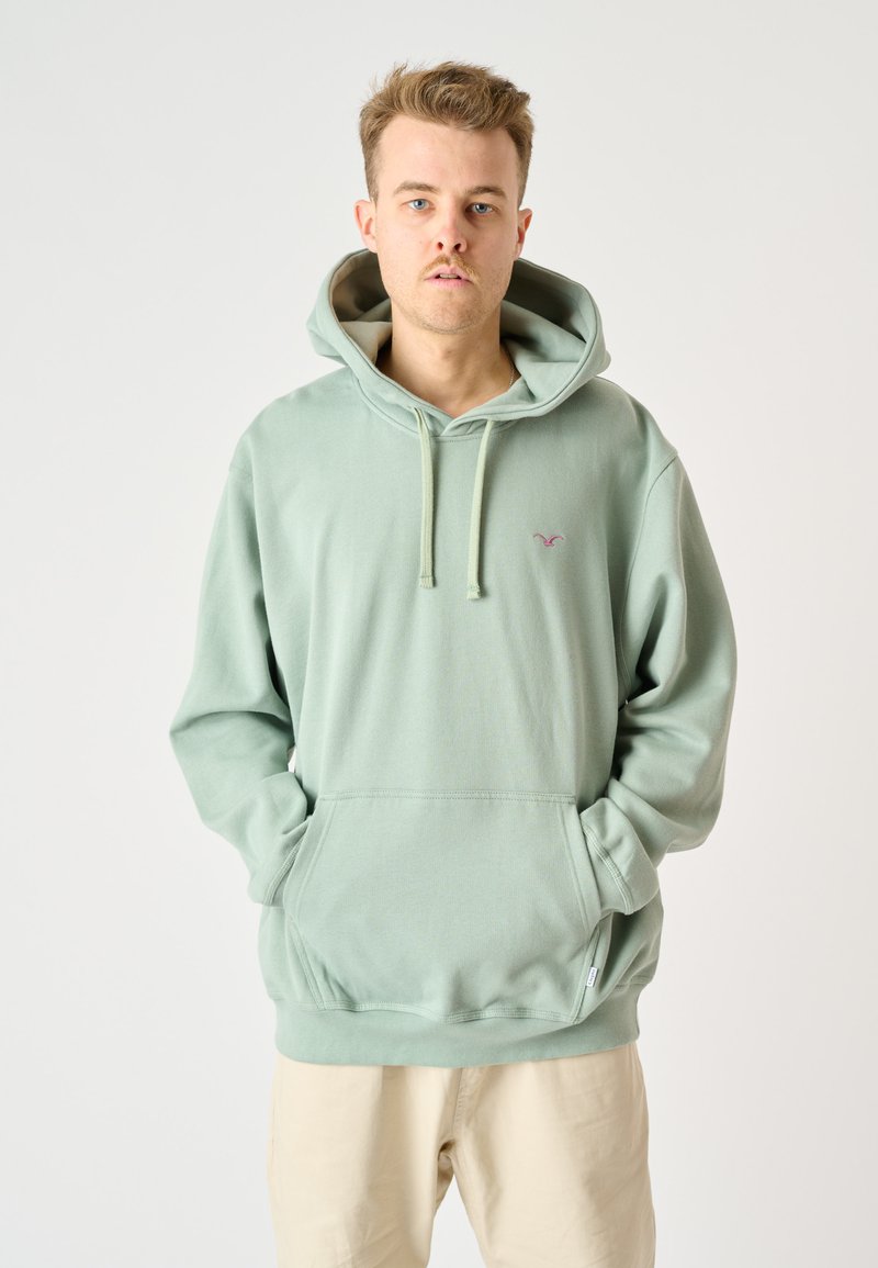 Light green hoodie with a large front pocket, drawstrings, and a small logo on the left chest. Soft fabric, relaxed fit.