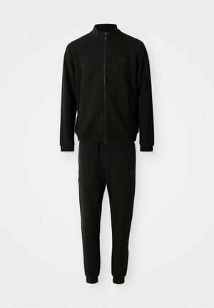 Black tracksuit featuring a zip-up jacket with a stand collar and matching pants. Made of smooth fabric with subtle logo detailing.