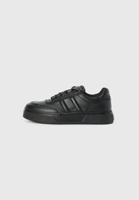 Adidași cu platformă negri, realizați din piele netedă, având un profil scăzut, vârf rotund, talpă texturată și trei dungi laterale pentru un detaliu de design.