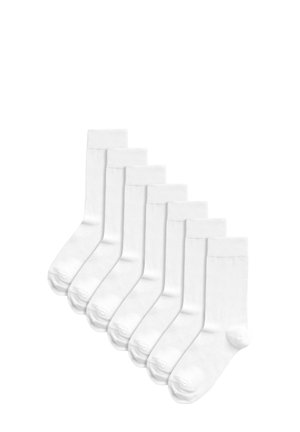 Vita bomull crew-strumpor med ribbad mudd, förstärkt häl och slät textur, ordnade i en rad. Set med sju par.