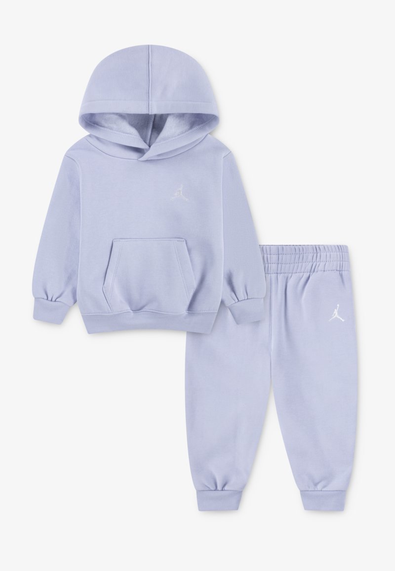 Lyslilla hoodie og joggersæt lavet af blødt stof. Hoodien har en frontlomme og et lille logo; joggersne har elastiske manchetter og talje.