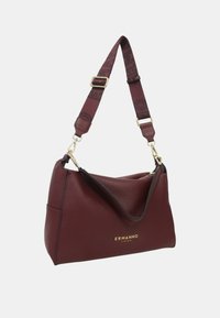 Borsa in pelle bordeaux con una texture morbida, dotata di un bordo accentuato nero e di un logo dorato. Tracolla regolabile con branding a contrasto.