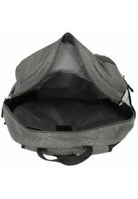 Mochila de tela gris con un interior amplio forrado y cierre de cremallera. Cuenta con asas dobles y un bolsillo de malla en el lateral.