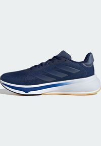 Chaussure de sport bleu marine avec dessus en mesh, trois bandes latérales, semelle intermédiaire blanche, accent bleu et bord de semelle extérieure jaune clair.
