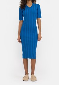 Abito a maglia blu a coste con scollatura a V e maniche corte, caratterizzato da una vestibilità aderente e un orlo fino al ginocchio. Tessuto morbido, dettagli minimi.