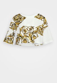 Zkrácený tričko z bílé bavlny s výrazným zlatým barokním květinovým vzorem, se krátkými rukávy a kulatým výstřihem.