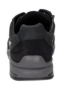 Chaussure de sport noire avec un dessus en cuir lisse, accents en daim doux, col rembourré et semelle en caoutchouc texturé avec un détail de logo.