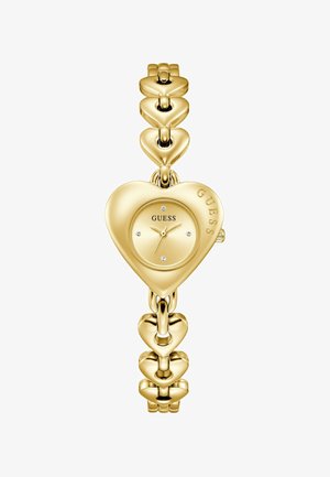 Goudkleurig hartvormig Guess-horloge met een armband van gekoppelde harten en kristallen uurmarkeringen op de wijzerplaat.