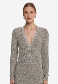 Grå och vit stickad cardigan med djup V-ringning, långa ärmar och knappstängning. Har texturerad stickad tyg och en kortad design.