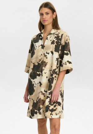 Korte mouw jurk in een beige en bruine koeienprint, met een kraag en een ontspannen pasvorm met een rechte zoom.