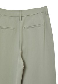 Pantalons ajustés vert clair, en mélange de polyester, avec une texture lisse, une fermeture éclair dissimulée et deux poches arrière au design épuré.