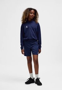 Marineblauw sportoutfit bestaande uit een longsleeve met halve rits en bijpassende short, gemaakt van flexibel materiaal met logo details.