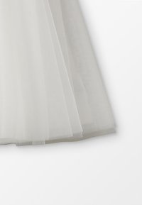 Grijze tule rok met gelaagd, doorschijnend ontwerp. Zachte textuur, vloeiende vorm en knielange snit. Delicaat en lichtgewicht uiterlijk.