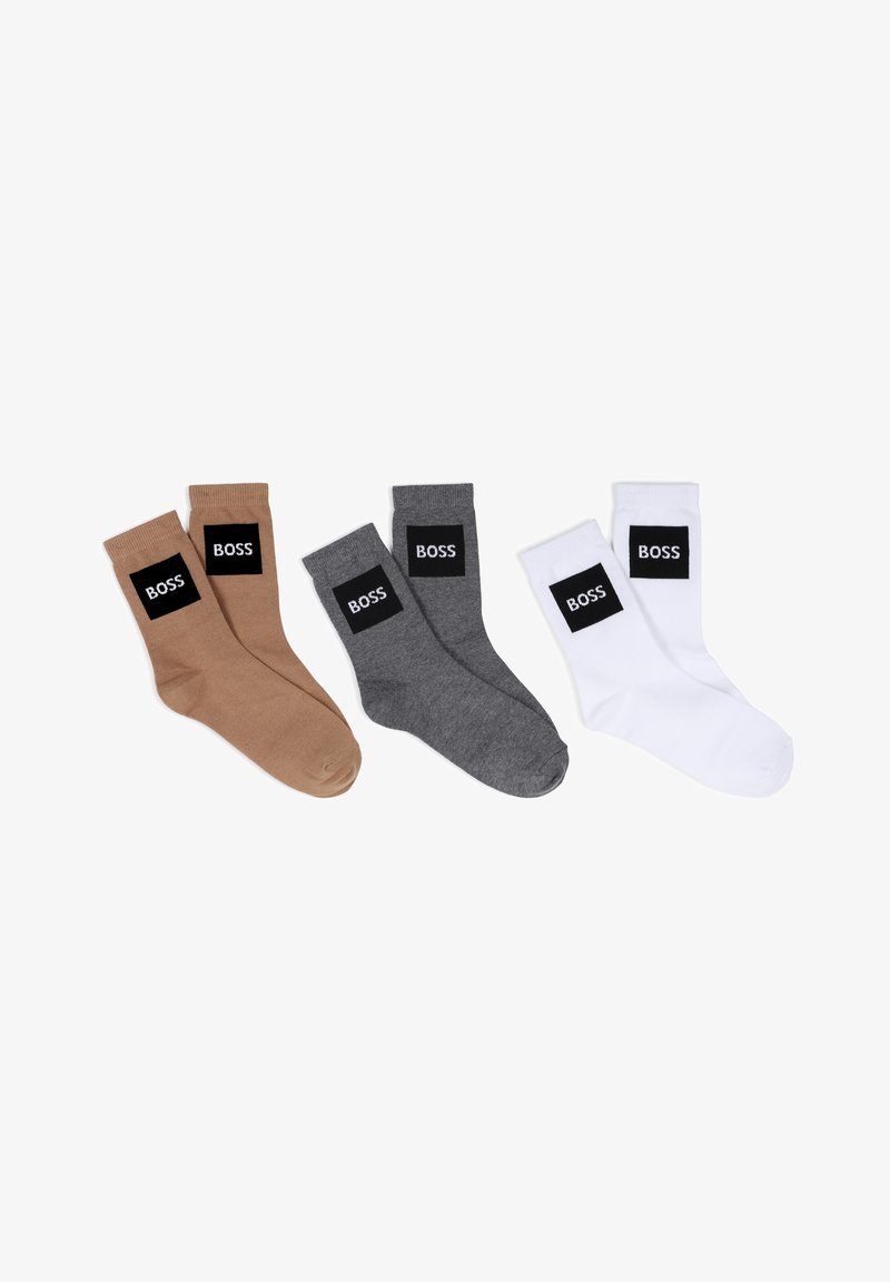 Chaussettes marron, grises et blanches avec un patch rectangulaire noir affichant le logo "BOSS". Fabriquées en mélange de coton, elles présentent une texture lisse.