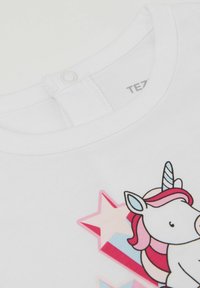 Bílý bavlněný tričko s kulatým výstřihem. Obsahuje potisk jednorožce v růžové a modré barvě, doplněný o hvězdičky v odstínech růžové a bílé.