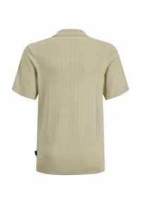 Polo en maille beige à manches courtes avec motif carré texturé et col et poignets côtelés, vu de dos.
