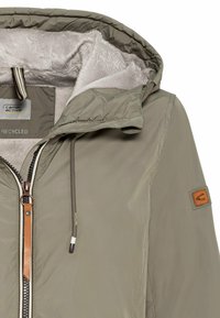 Recycled material jacket in light grey with a faux fur lining. Features a hood, zip closure, and leather accents on the zipper and arm patch.