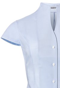 Camicia azzurra a maniche corte con collo rialzato, caratterizzata da una chiusura frontale con bottoni e una texture sottile. Etichetta visibile all'collo.