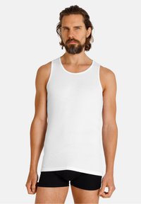 Witte geribbelde tanktop met een ronde hals, gecombineerd met zwarte shorts. De pasvorm is snug en gemaakt van een katoenmix.