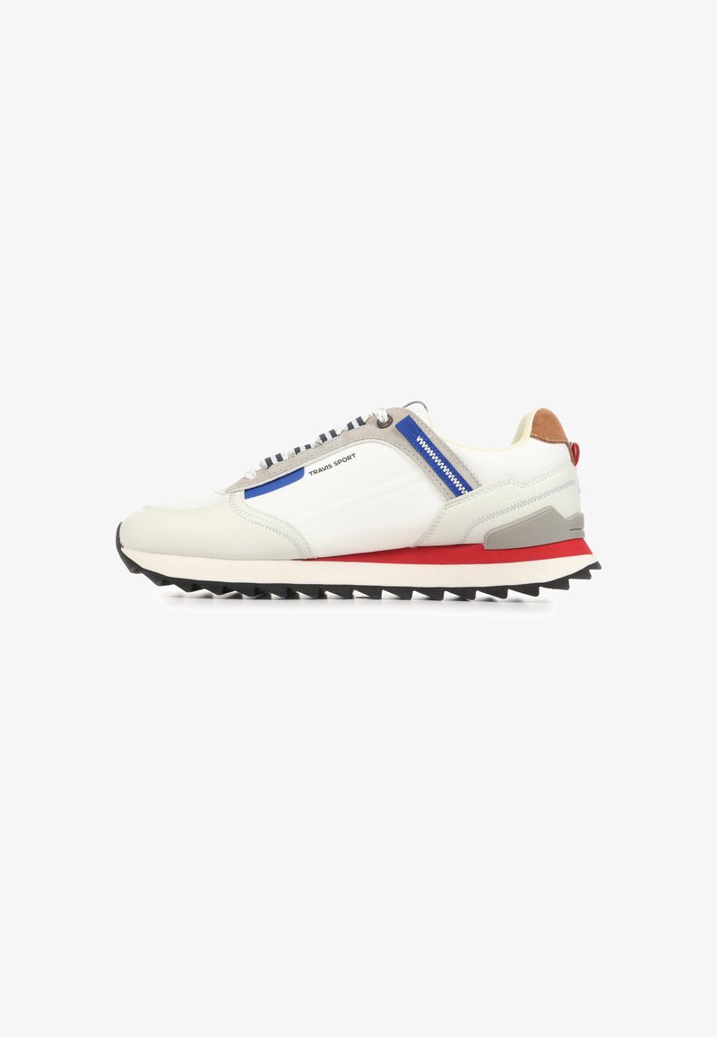 Weiße und beige Sneaker mit niedrigem Schaft, blauem Reißverschlussdetail, rotem Streifen auf der Zwischensohle, schwarzer Sohle mit Profil und dem Schriftzug "Travis Sport" an der Seite.