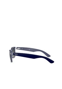 Occhiali da sole trasparenti con montatura rettangolare, fronte trasparente e aste blu scuro. Presentano il marchio Ray-Ban sulle aste. Fabbricati in Italia.